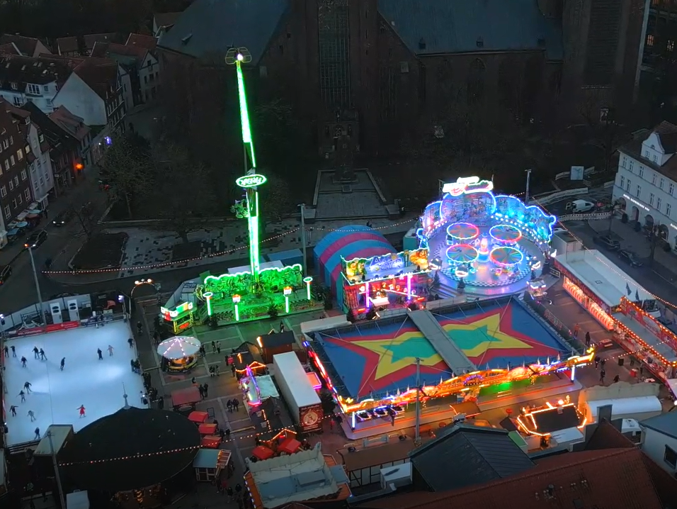 Blick aus der Luft auf den Neuen Markt in Stralsund mit Fahrgeschäften und Eisbahn