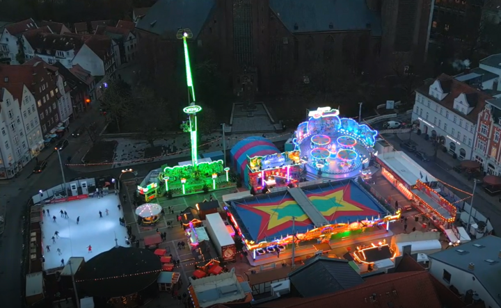 Blick aus der Luft auf den Neuen Markt in Stralsund mit Fahrgeschäften und Eisbahn